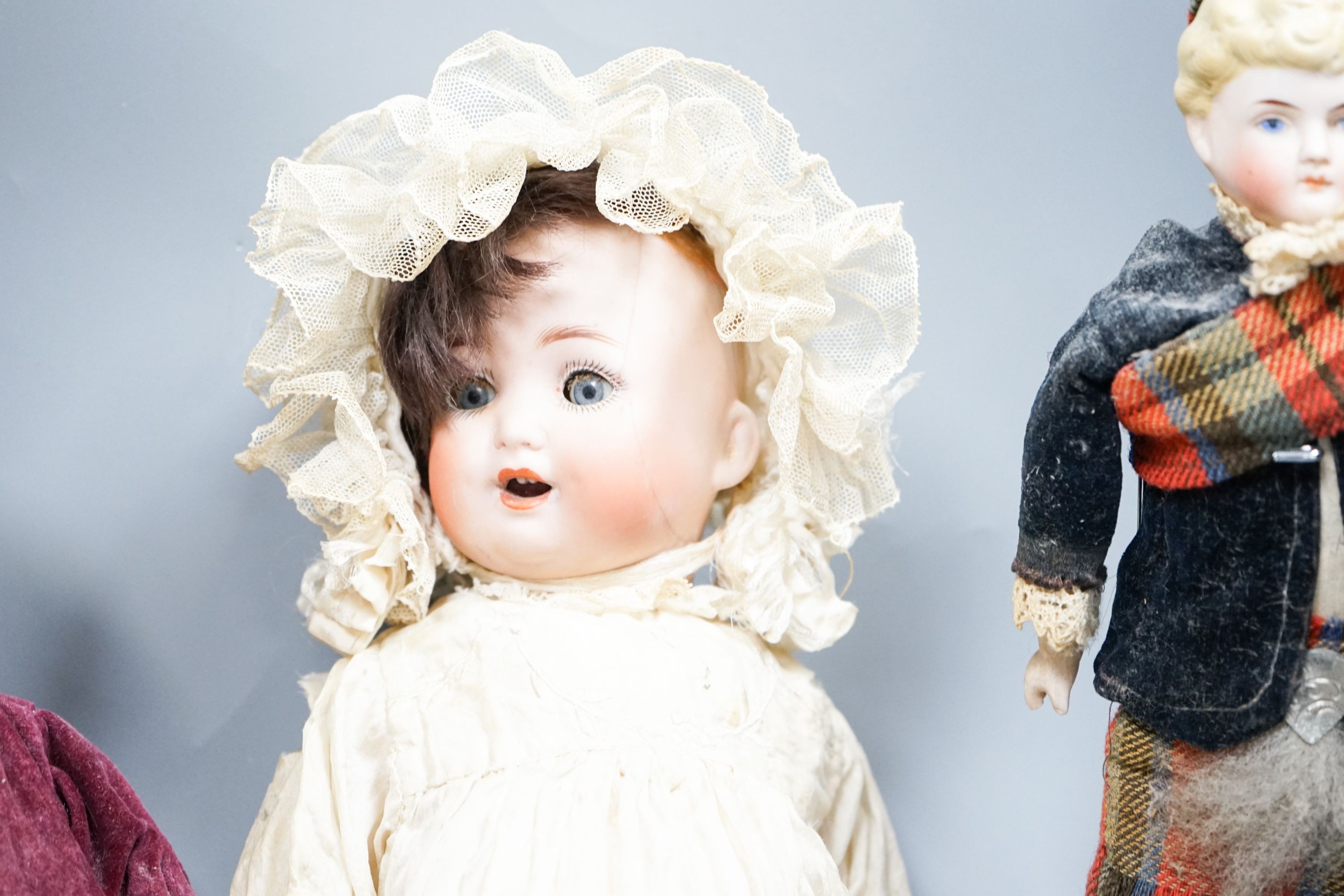 A German bent limb face cracked H12in. German bent limb character baby H9in. bisque head Scottish doll with bisque shoes and hands H10in.